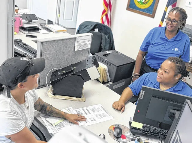 Garland Department of Motor Vehicles employees Best and Anders assist Alysha Torres obtain her North Carolina drivers license. Best and Anders declined to give their first names. Torres, a Cumberland County resident, travelled an hour on Monday morning to the Garland DMV, and agreed afterwards that she still saved time.
Dylan Atwood | Sampson Independent