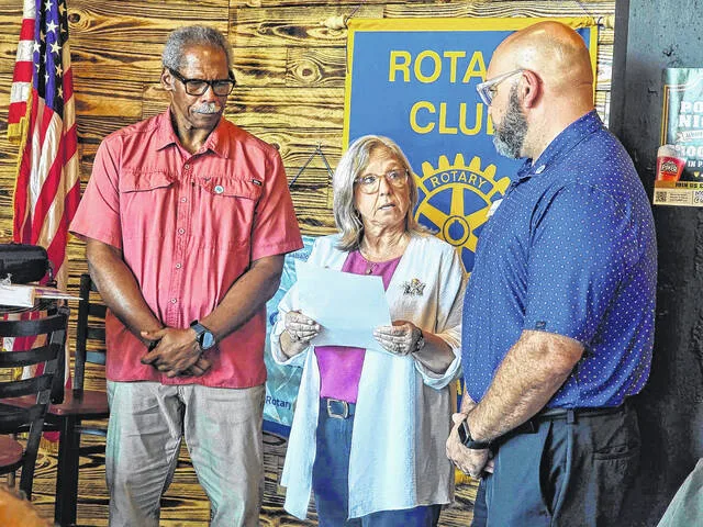 Shawn Braswell, District Governor of Rotary District 7730, which includes Sampson, inducts the YMCAs William Nunez, far right, into the noon-day clubs membership during Mondays meeting at R&R Kitchen and Taproom. Assisting with the induction is Clinton-Sampson Rotary President Dr. Ted Thomas.