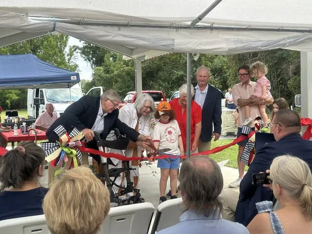 Earl McDaniel together with his wife Bridget and their family, with Mayor Joe Warren and his wife Linda, cut the ribbon to officially open Love McDaniel Memorial Park.