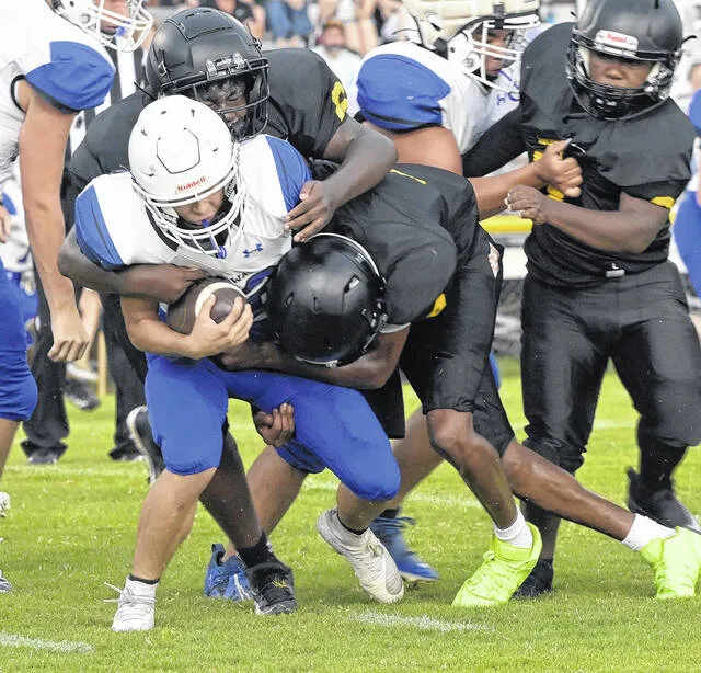 Wildcats Camden Brown and Cameron Moore swarm Midways Hunter Batten in the backfield.
                                 David Johnson | Sampson Independent