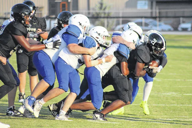 Clintons Jeremiah Faison pulls a pile of Raider defenders on his way toward the goal line in their junior varsity matchup Wednesday evening. The Dark Horses defeated Midway 34-0.
                                 Trevon McGlone | Sampson Independent