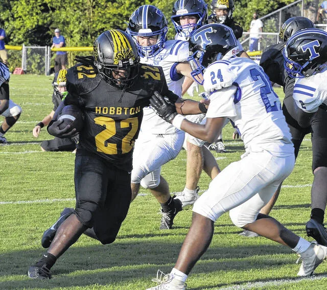 Hobbton sophomore Javarus Johnson pushes off Tritons Charles Anderson, as he twists out of a tackle for a few more yards.
                                 David Johnson | For the Sampson Independent