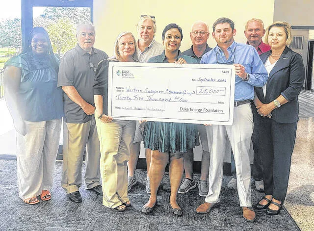 Members of Western Sampson Commerce Group pose with Duke Energy District Manager Pam Hardy as she presents the nonprofit with a check for $25,000 which will fund small business grants in Western Sampson County.