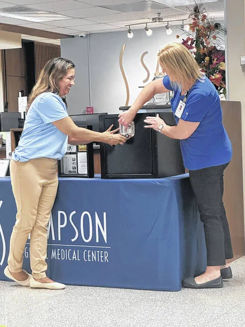 Clinical Nurse Educator Kathryn Canady, left, along with Shannon Capps, director of Obstetrics, seal the time capsule that will be opened in 2050.