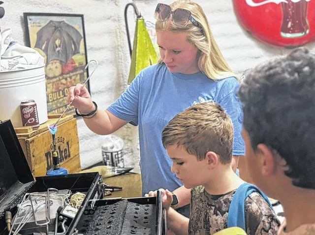 Jayna Jones creates a custom leather branded key chain for Jason Bills and Camden Warren during the hunt event. Jones offered free and unique branding work through her business, East Coast Branding Co., at the Kitty Fork Outdoors Annual Veterans Dove Hunt Saturday. Jones estimates she made somewhere over 30 custom pieces at the event.
Dylan Atwood | Sampson Independent