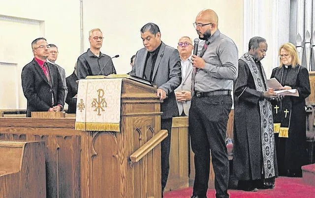 Pastor Jaime Carrion and Minister Christian Felipe, both of Jehovahs Arc International Ministry, read Romans 12:14-21 in Spanish and then English as part of the 9/11 Communion Service of Rembrance Friday at Graves Memorial Presbyterian Church.
                                 Photos by Claire Fox | Sampson Independent