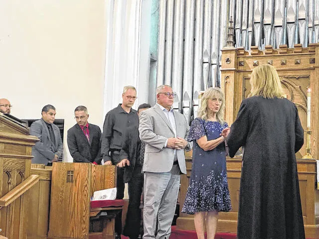 The Rev. Katie Rives first offers communion to the other leaders involved in the 9/11 service on Friday.
                                 Photos by Claire Fox | Sampson Independent