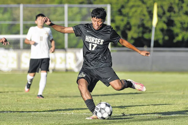 Clintons Alven Ramirez crosses a pass in front of the goal for a strike to a breaking teammate for the Dark Horses second goal during first-half action against James Kenan Tuesday. The Dark Horses won 3-2.
                                 Mike Carter | For the Sampson Independent