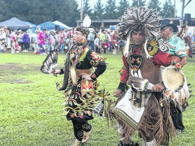 Makayla Carter and her father, Matthew Carter, help lead the Grand Entry Friday evening during the 56th annual Coharie Pow Wow. Chief Gordon Jacobs walks behind them.
                                 Dylan Atwood | Sampson Independent