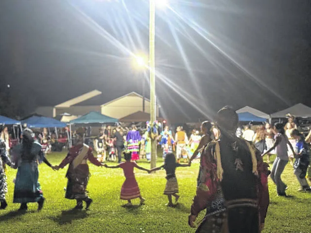 Generations link hands in fellowship and community during Friday nights annual Pow Wow.
                                 Dylan Atwood | Sampson Independent