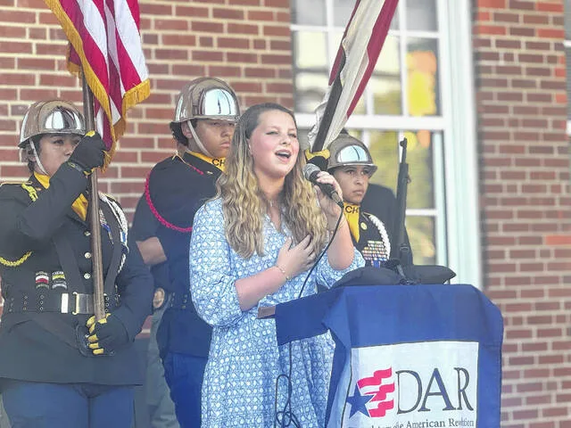 Clinton High School JROTC Color Guard cadets Karina Garcia Roldan, Leandro Colman, and Zoe Cruz present the colors as Matilda Parker performs the national anthem during Thursdays National Ringing of the Bell ceremony.
                                 Dylan Atwood | Sampson Independent